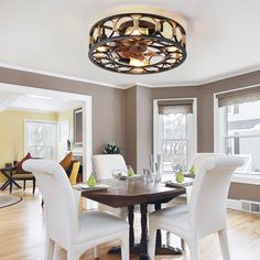 a dinning room table with white chairs and a round light fixture above the table