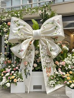 a large white bow with flowers around it