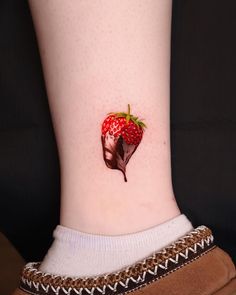 a strawberry on the side of a woman's leg with chocolate covered strawberries