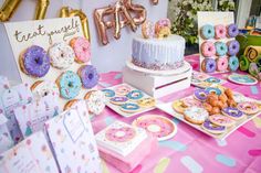 a table topped with lots of donuts covered in frosting and sprinkles