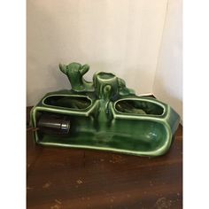 a green ceramic soap dish sitting on top of a wooden table