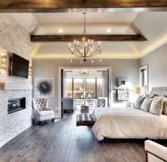 a large bedroom with wood floors and a fireplace in the corner, along with a bed that has pillows on it