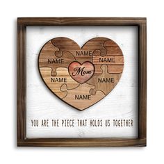 a heart shaped puzzle with the words name mom and two names on it in a wooden frame