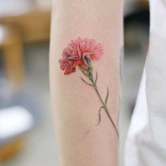 a woman's arm with a pink flower tattoo on the left side of her leg