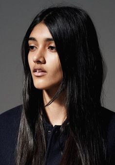 a woman with long black hair is looking at the camera while wearing a black shirt