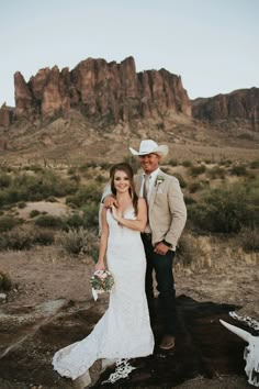 a bride and groom posing for a photo in the desert