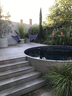 there is a small pool in the middle of this yard with steps leading up to it