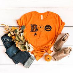 an orange t - shirt that says boo bees on the front and back, next to some fall leaves