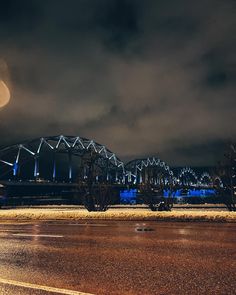 an image of a bridge at night with the moon in the sky