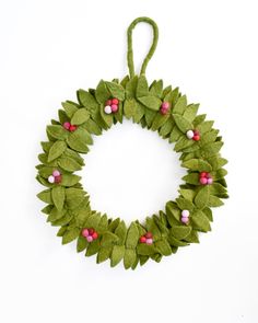 a wreath made out of felt and green leaves