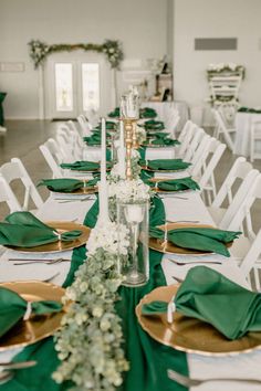 the table is set with green napkins and place settings