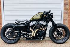 a black and gold motorcycle parked in front of a garage