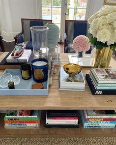 the coffee table is filled with books and vases