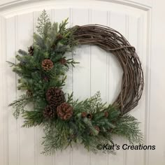 a wreath with pine cones and evergreen branches