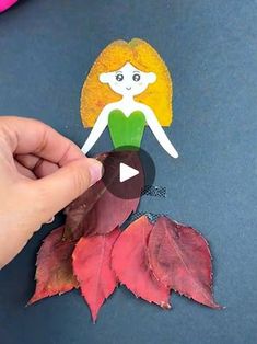 someone is making a paper doll out of leaves