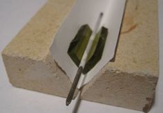 a pair of scissors cutting through a piece of cement with a sharp blade on it