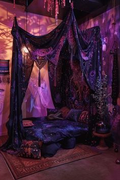 a purple canopy bed in a room with curtains on the ceiling and lights hanging from the ceiling