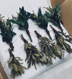 flowers and greenery are laid out on a white tablecloth with brown paper underneath