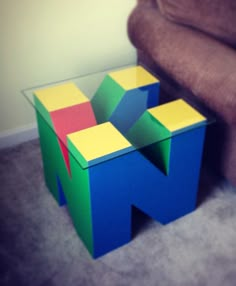 a small wooden block sitting next to a brown chair