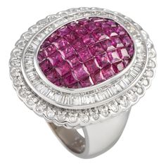 Polish your look with elegance and individuality with this cocktail ring. This LB Exclusive piece makes a bold statement with its thick and domed shank, and its domed cluster of rubies set on an oval bezel. The pinkish-red centerpiece holds rubies totaling 2.56 carats. Surrounding the mesmerizing center is a bezel halo of step-cut diamonds. A scalloped halo with round diamonds further frames the centerpiece for an extra dramatic finish. The ring's top dimensions measure 18mm by 25mm.This 18K Whi Red Centerpieces, Pinkish Red, Step Cut, Color Rojo, Cocktail Ring, Cocktail Rings, Statement Ring, Round Diamonds, Statement Rings