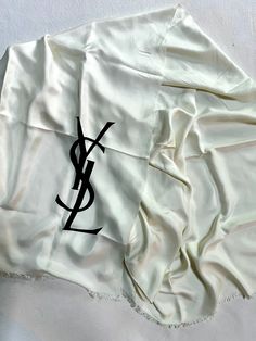 Vintage 1970s Yves Saint Laurent YSL white 100% silk foulard scarf / stole / shawl  * extremely rare, very large * white silk with large black YSL logo (color is white even though some photos it appears more ivory) * fringed edges label: marked YSL and has Made in France label (see photo) material: 100% silk measurements: approx 35.5" wide and approx. 70" long condition: excellent vintage. no flaws found all items are final sale, please review information before purchasing **I use recycled shipping envelopes / boxes. Please let me know if you do not want that** White Silk Scarf Shawl, White Silk Shawl Scarf, White Silk Shawl Scarf For Summer, Luxury White Silk Scarves, Designer White Silk Scarves, Shipping Envelopes, Ysl Logo, White Silk, Logo Color