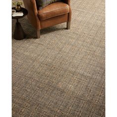 a brown chair sitting on top of a rug