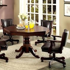 a dining room table with chairs around it and a bowl of fruit on the table