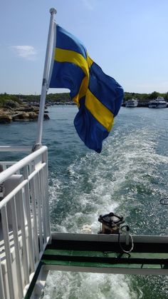 the swedish flag is flying from the back of a boat