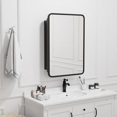 a bathroom with white walls and black accents on the vanity, mirror and stool in front of it