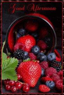 berries, raspberries and strawberries in a red bucket on a black surface