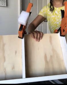 a woman is holding two pieces of plywood