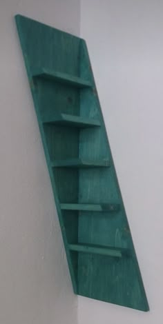 a green shelf mounted to the side of a wall