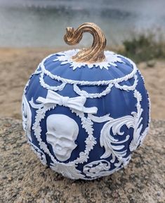 a blue and white pumpkin sitting on top of a rock