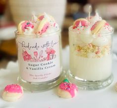 two jars filled with cookies and marshmallows on top of a white table