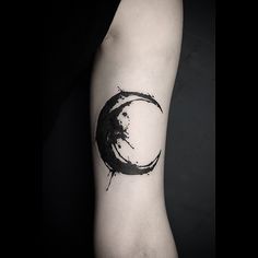 a black ink circle tattoo on the arm