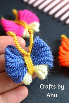 someone is holding two small crocheted flowers in their hand, with the words crafts by anu written below them