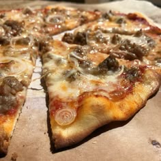 a pizza sitting on top of a pan covered in cheese and meat toppings with one slice missing