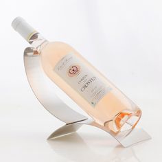 a bottle of wine sitting on top of a metal stand