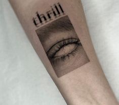 a close up of a person's arm with an eye and the word thrill on it