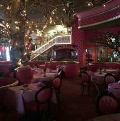 the interior of a fancy restaurant with pink and gold decor