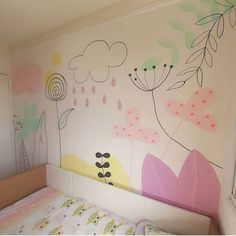 a child's bedroom with painted flowers on the wall, and a small bed