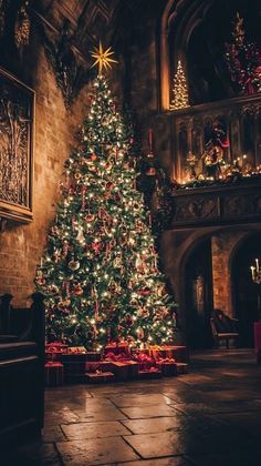 a large christmas tree is lit up in an old building