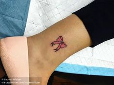 a small bow tattoo on the ankle