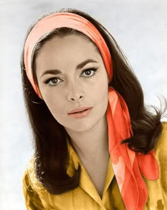 black and white photograph of woman with scarf around her neck looking at the camera while wearing a blouse