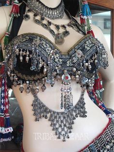 a mannequin with jewelry on it's chest and headpieces hanging from the neck