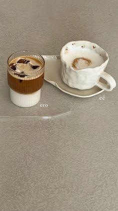 a coffee cup and saucer sitting on top of a glass plate next to each other