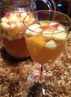 two glasses filled with liquid sitting on top of a counter next to each other and the words, witched autumn apples sangria