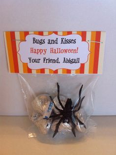 a spider is wrapped in plastic and sitting next to some candies on a table