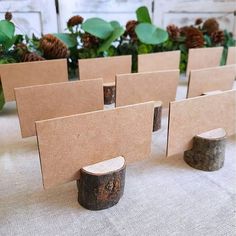 several pieces of cardboard sitting on top of a table next to some logs and pine cones