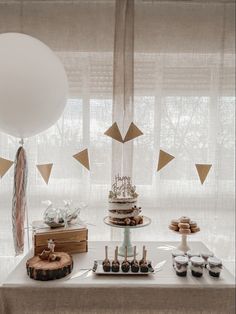 a table topped with cake and desserts next to a window